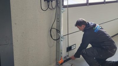 Intervention d'un équipier Somaferm pour la maintenance d'une porte sectionnelle dans les Hauts-de-France.