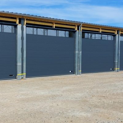 Façade extérieure du hangar de Campagnes Services avec 7 portes sectionnelles installées par Somaferm