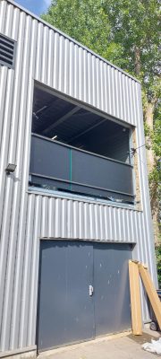 Grille DENTEL motorisée en cours d'installation sur un bâtiment industriel